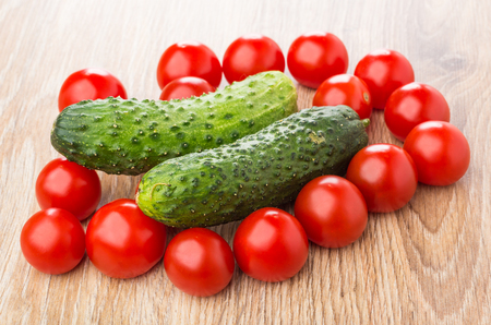 Tomato cherries and cucumbers on wooden tableの写真素材