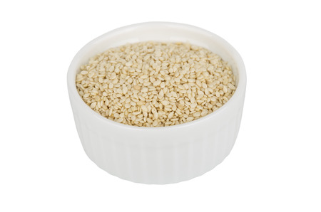 Glass bowl with sesame seeds isolated on white backgroundの写真素材