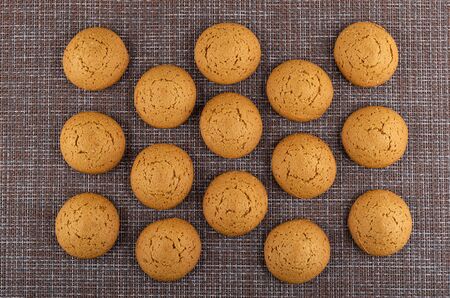 Background from many oat cookies on dark mat. Top view