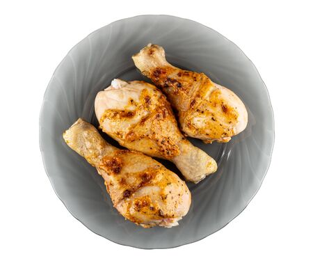 Three grilled chicken legs in gray glass plate isolated on white background. Top viewの写真素材