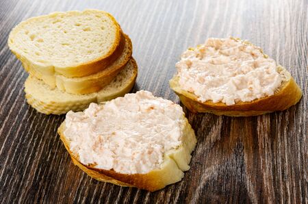 Few pieces of wheat bread, sandwiches with krill paste on dark wooden tableの写真素材