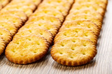 Several rows of round crackers on wooden tableの写真素材