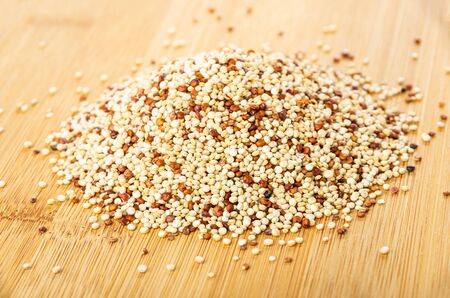 Heap of quinoa seeds on wooden tableの写真素材