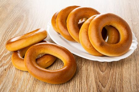 Big bread rings (baranka) in white dish, bread rings on wooden table