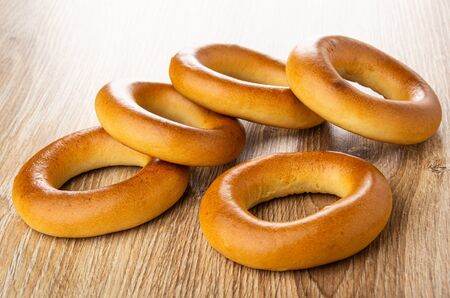 Scattered big bread rings (baranka) on wooden table