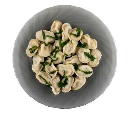Boiled dumplings with greens in gray plate isolated on white background. Top viewの写真素材