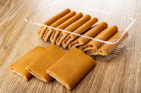 Cookies with filling in transparent plastic box, cookies on wooden table