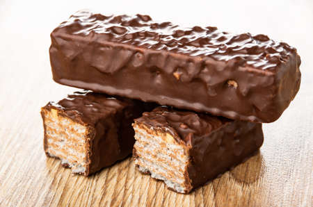 Whole wafer in chocolate glaze, halves of wafer on wooden table