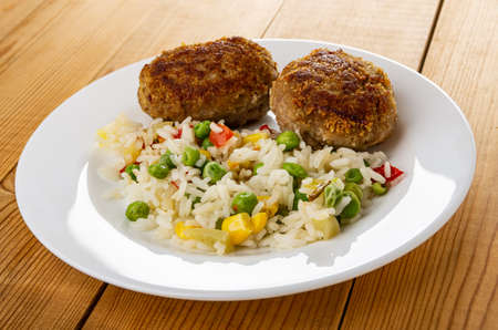 Hawaiian blend with fried meat cutlets in white plate on wooden tableの写真素材