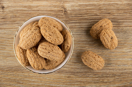Crispy oat pillows with filling in white bowl, few crispy pillows on brown wooden table. Top viewの写真素材