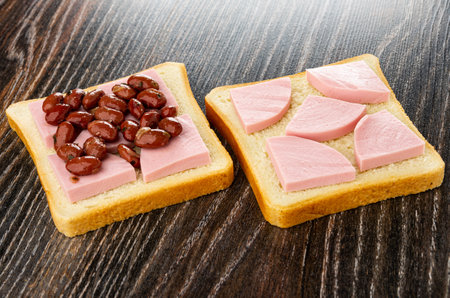Sandwich with sausage and red bean, sandwich with sausage on dark wooden table