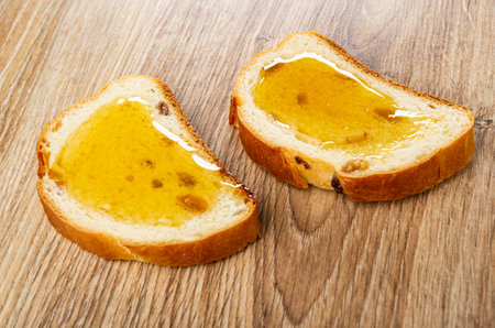 Two sandwiches from rich bread with raisin and honey on wooden tableの写真素材