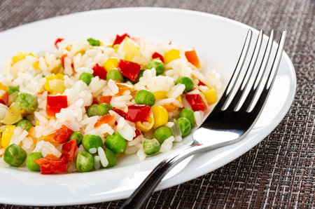 Close up of vegetable blend and fork in white plate on dark matの写真素材