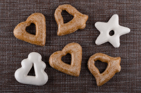 Few brown and white gingerbreads different shape on dark mat. Top viewの写真素材