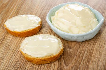 Sandwiches with cream cheese, light-blue bowl with cream cheese on wooden tableの写真素材