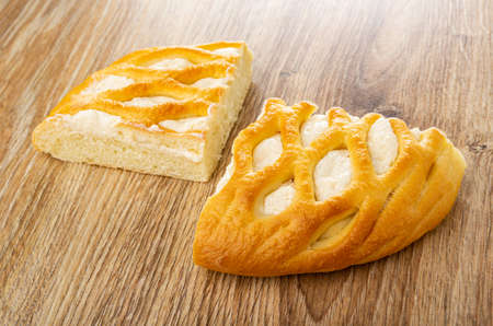 Two pieces of wicker sweet pie with cottage cheese on wooden table