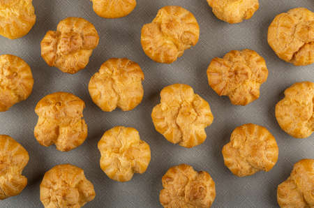 Background from many of profiteroles on gray table. Top view