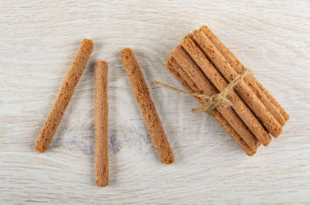 Crusty sticks on wooden table, bunch of brown sticks with cream filling on table. Top view
