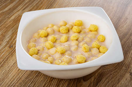 White owl with corn balls and fruit yogurt on wooden table