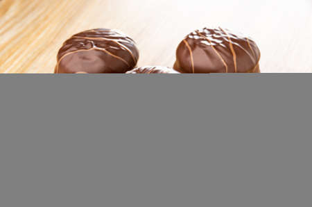 Stacks of round striped chocolate candies on brown wooden table