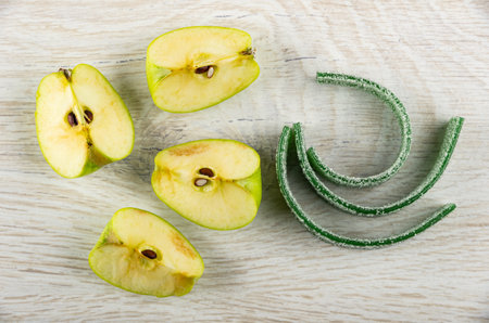 Slices of apple, twisted thin strips of green marmalades on wooden table. Top viewの写真素材