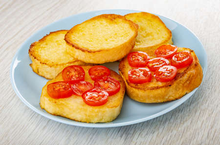 Toasted wheat bread, sandwiches with tomato cherry in blue plate on wooden table