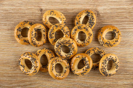 Scattered bread rings with poppy seeds on brown wooden table. Top viewの写真素材