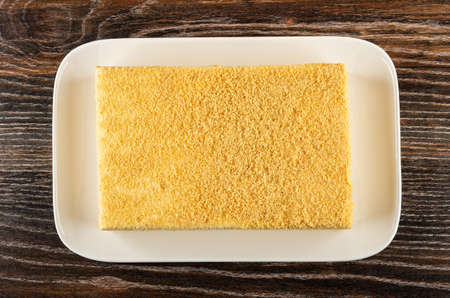 Cottage cheese and yogurt cake with shortcrust crumbs in glass plate on dark wooden table. Top view