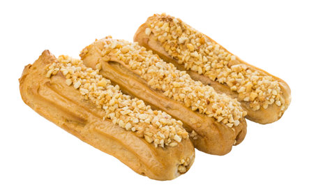 Three eclairs with pieces of peanuts isolated on white background