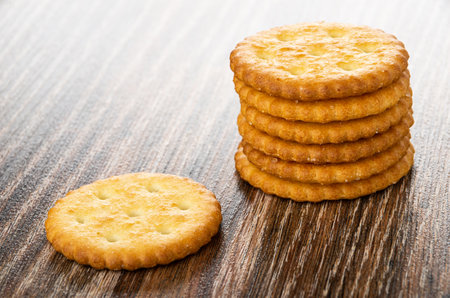 Stack of salted crackers on dark wooden tableの写真素材