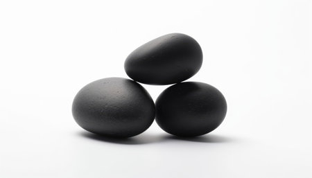 Three black stones isolated on a white background. The concept of zen and a healthy lifestyle.の素材