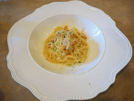 Spaghetti carbonara with bacon, cream and cheese sauce served on a white plateの写真素材