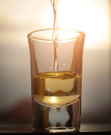 A shot of an alcohol beverage being drunkの写真素材