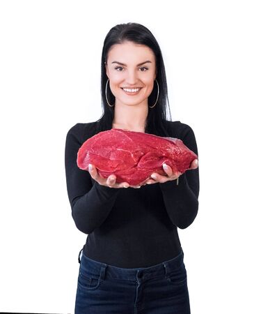 Beautiful housewife laughing and holding a big meat pieceの写真素材