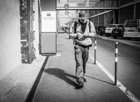 Genoa, Italy - April 21, 2016: Young Italian man 
 chatting using the phone and walking by the street  in  in Genoa, Italyのeditorial素材