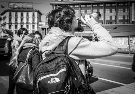 Milan, Italy - March 23, 2016: Man drinking a water from the bottle on the italian street in Milan, Italyのeditorial素材