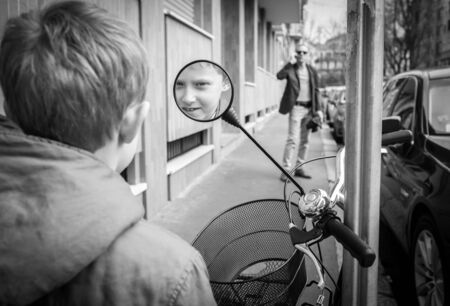 Little boy smiling at the scooter rear view mirrorのeditorial素材