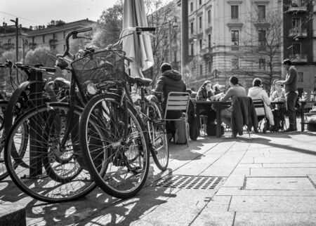 Milan, Italy - March 23, 2016:  Bicycles waiting the owners, who have a lunch at outdoor cafe on italian street in Milan, Italyのeditorial素材
