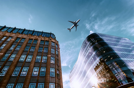 Jet plane aircraft traveling in the sky over the center of Glasgow city buildings. の写真素材