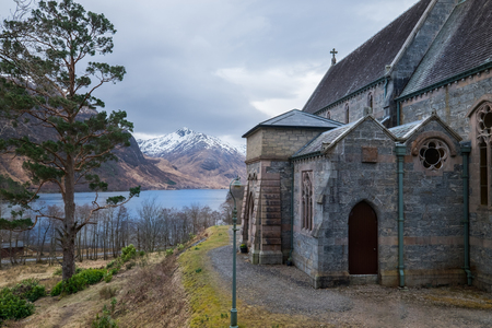 Glenfinnan Church with Loch Shiel Lake view and snowy Highlands mountain peaksの写真素材