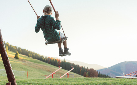 Little Boy swinging on the mountain kids park playground