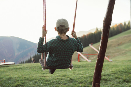 Little Boy swinging on the mountain kids park playgroundの写真素材