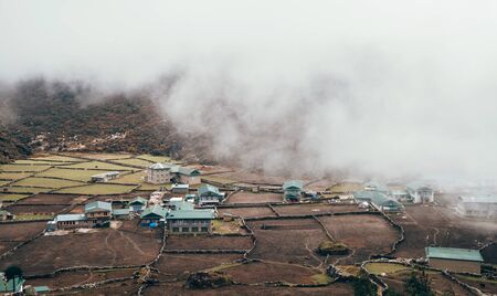 Khumjung Village View with heavy clouds over settlement . Everest Base Camp (EBC) trekking route. Sagarmatha National Park, Nepal.の写真素材