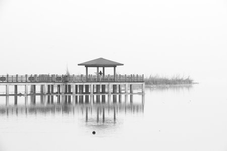 Wooden pier on the lake in the fog, black and whiteの写真素材