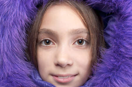 Smiling girl wearing purple fur hood close-up portraitの写真素材