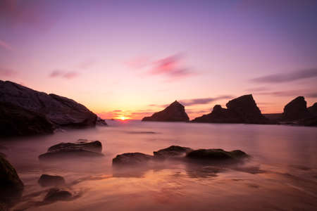 Bedruthan Steps at sunset with violet skies, Cornwall, Englandの写真素材