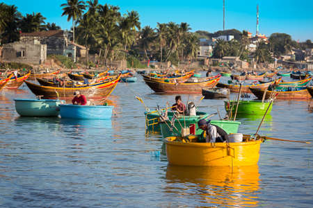 MUI NE, VIETNAM - FEBRUARY 08 - Fishermen in traditional small fishing boatsのeditorial素材