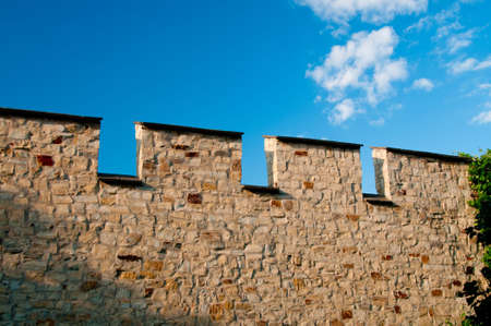 medieval stone wall against blue skyの写真素材