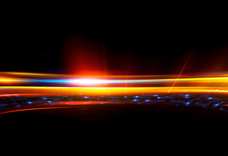 Beautiful light flares. Glowing streaks on dark background. Luminous abstract sparkling lined...