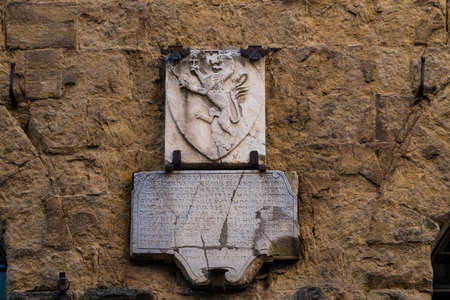 A commemorative stone with on top a rampant lion in San Gimignano, Tuscany, Italy. The wrinting is dated back to middle-ageの写真素材